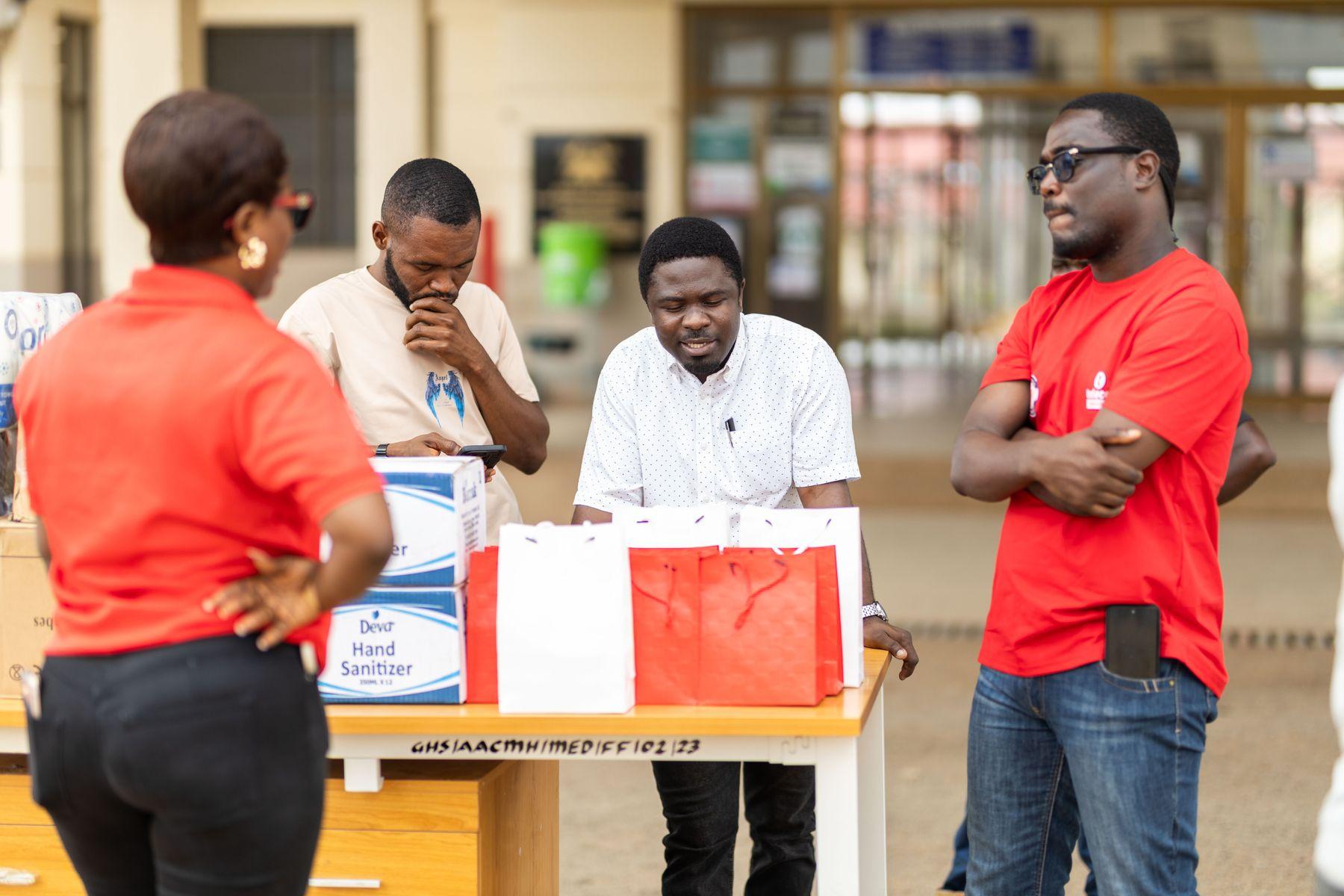 Two volunteers handing over a box of medicine